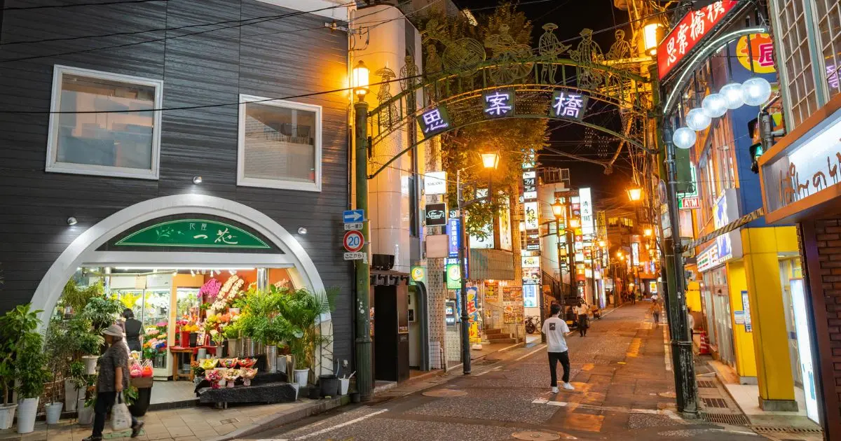 夜の思案橋。アーケードの「思案橋」の文字と灯りのともる通り